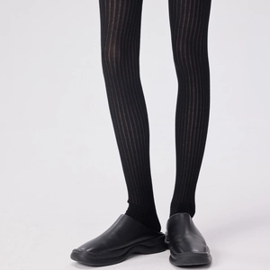 Close-up of black vertical striped over-knee socks paired with matte leather mule shoes