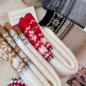 Close-up of Nordic knit leg warmers with snowflake patterns and warm wool texture