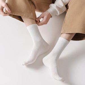 Detail of white Tabi socks with ribbed cuffs and breathable mesh texture on the foot