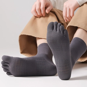 Detail of dark grey five-finger socks with ribbed cuffs and textured knit on feet