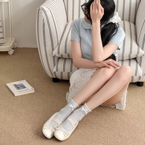 Light blue knit socks with white bow accents paired with cream Mary Jane ballet flats