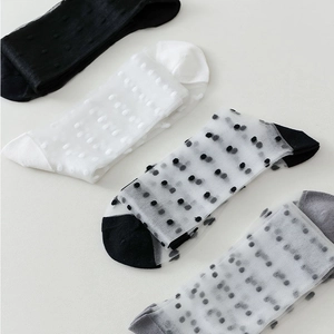 Set of four sheer polka dot knee-high socks in black and white mesh for women