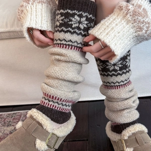 Close-up of vintage snowflake pattern knitted leg warmers styled with suede boots