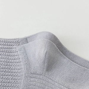 Detailed macro view of light purple over-knee socks featuring vertical rib knit texture