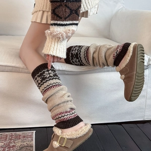 Detail of grey knitted Fair Isle leg warmers with khaki and dark brown pattern