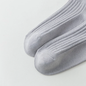 Detailed macro view showing vertical ribbing and fine stitching on light gray knit socks