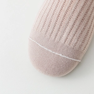 Detailed macro view of pink over-the-knee socks showing fine knit texture and toe seams