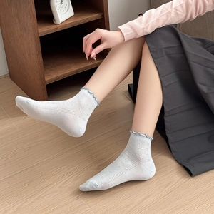 Close-up of light blue ruffle trim ankle socks with heart-shaped breathable mesh patterns