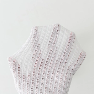 Detail of white breathable knitted mesh fabric showing vertical stripes and texture