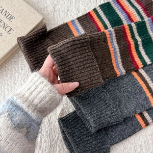 Close-up of thick striped knit leg warmers with soft wool texture and ribbed edges