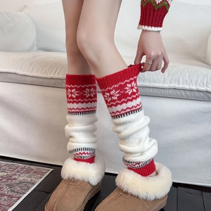 Red and white Christmas knit leg warmers with snowflake patterns and soft wool texture
