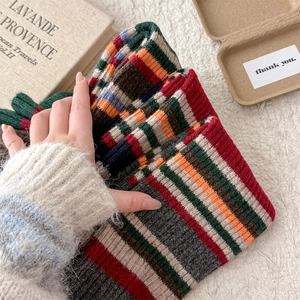 Close-up of thick striped knit leg warmers with vintage multi-color pattern and texture
