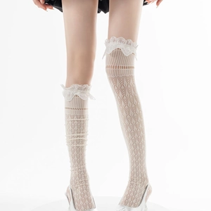 Détail de bas en dentelle blanche avec broderies florales et bords à volants doux