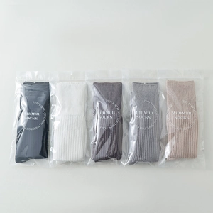 Detailed view of five multi-colored ribbed knit socks in individual retail packaging