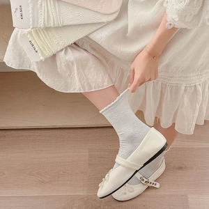 Detail of sweet floral lace crew socks with scalloped edges paired with Mary Jane shoes