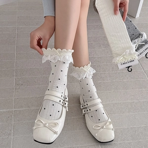 Détail de chaussettes Lolita à pois blancs avec bordure en dentelle et nœud en ruban