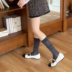 Detail of grey ribbed calf socks paired with quilted monochrome Mary Jane shoes