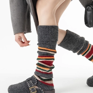 Detail of vintage striped knit leg warmers showing thick ribbed texture and multi-color bands