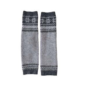 Grey knit leg warmers featuring Nordic snowflake patterns in a classic long pile style