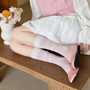 Detail of white vertical stripe mesh high socks paired with pink satin Mary Jane flats