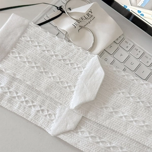 Detail of white knit cable pattern socks with hollow texture on a modern lifestyle background