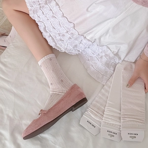 Detailed view of sheer floral embroidery socks and lace hollow textures in soft pink and white