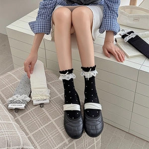 Détails de chaussettes Lolita avec dentelle, nœuds et pois sur un fond minimaliste chic