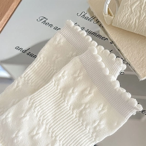 Macro shot of white textured floral crew socks with sweet scalloped lace edges