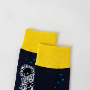 Detailed knit texture of astronaut themed crew socks with yellow ribbed cuffs