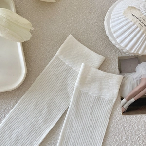 Detail of white vertical striped knee-high socks with high-elastic ribbing cuffs