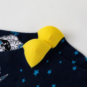 Detail of knit star pattern and yellow heel stitching on navy astronaut crew socks