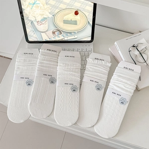 Set of five white cable-knit mid-calf socks with various textures in aesthetic packaging