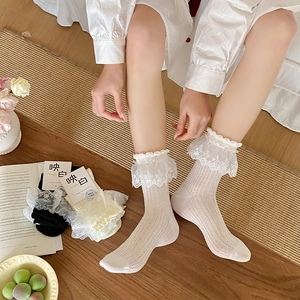 Nahaufnahme von Lolita-Socken mit Spitzenborte in Weiß, Schwarz und Beige, Vintage-Stil