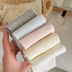Close-up of pastel textured cotton socks with ruffled edges in five soft colors