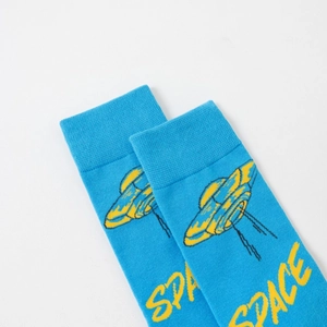 Detail of bright blue cotton sock featuring a yellow UFO pattern and SPACE text
