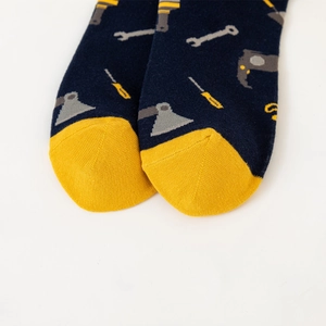 Detailed close-up of dark blue cotton sock toe with yellow contrast and tool pattern