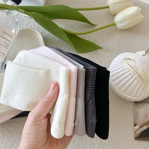 Close-up of ribbed cotton knee-high socks in pastel colors with soft textured finish