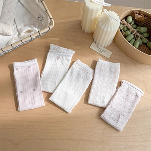 Detail of five pairs of sweet lace socks in white and pink with delicate floral embroidery