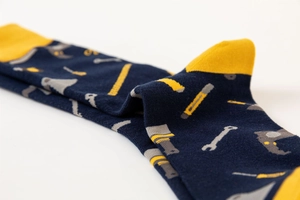 Detailed knit texture of navy blue socks with yellow tools pattern and reinforced heel