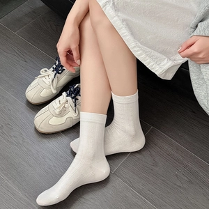 Detail of white cotton calf socks featuring delicate hollow heart cable knit patterns