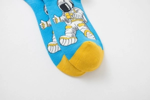 Close-up of bright blue cotton socks with yellow toe and astronaut cartoon pattern