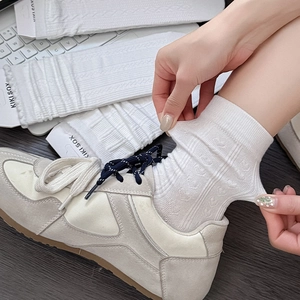 Detailed knit texture and high elasticity of white crew socks with geometric patterns