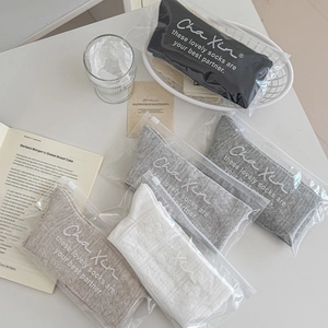 Detail of four pairs of ribbed ballet style knee socks in zipper bags on a desk