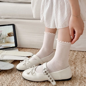 Detail of white double bow Mary Jane shoes paired with textured pink lace crew socks