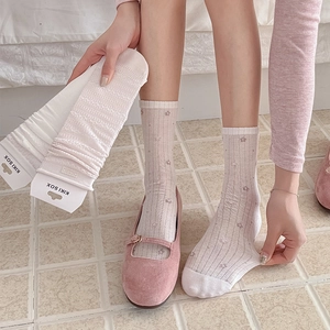 Detail of sweet lace crew socks with floral embroidery and hollow knit texture in packaging