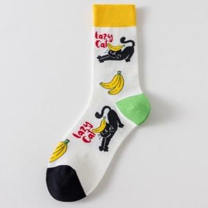 Detail of white cotton sock with cartoon black cat pattern and yellow banana prints