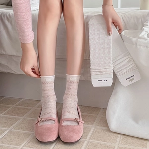 Detailed texture of white lace hollow-out mid-calf socks with delicate floral patterns