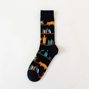 Detail of cotton crew socks featuring artistic bookshelves and an orange cat pattern