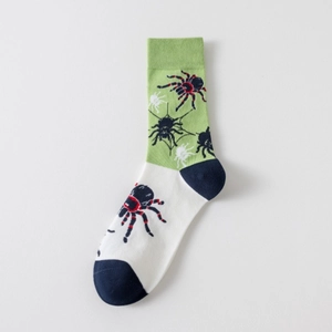 Détail de chaussettes en coton vert et blanc avec motifs jacquard d'araignée et toile