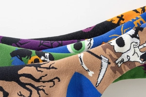 Dettagli di calze colorate lavorate a maglia per Halloween con motivi di ossa e ragnatela